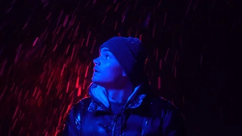 The young guy looks in different directions in surprise. Red and blue lighting Video stock 122296060