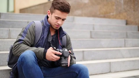 Young guy looks at the digital camera while in the city Stock Footage 81219649