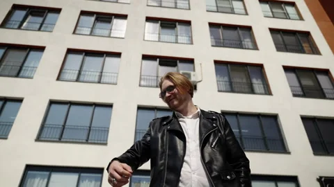 A young guy looks at the time on the clock. Brutal and stylish man against the Stock Footage 247132867