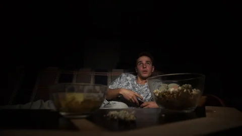 The young guy is lying on the bed and watching TV, switches channels Stock Footage 126093427