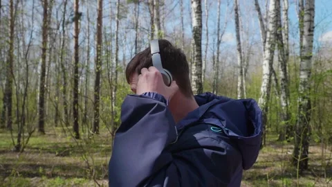 A young guy makes a run in the Park, listening to music through the headphones 库存影片 90382768