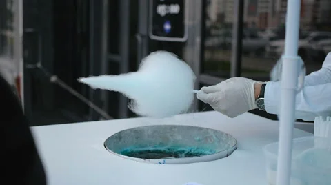 Young guy making cotton candy on a special machine, it wears bow tie, behind him Stock Footage 64041492