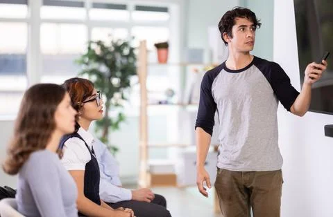 Young guy making presentation for students using digital board Stock Photos