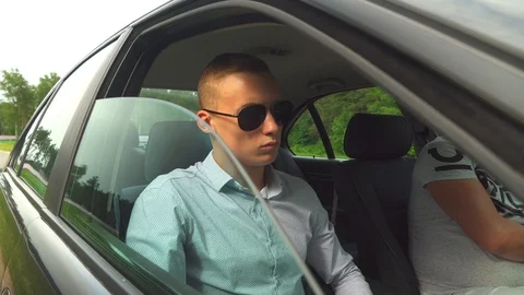 Young guy, man in sunglasses, in car and opens window, lowers side window. Stock Footage 112028050