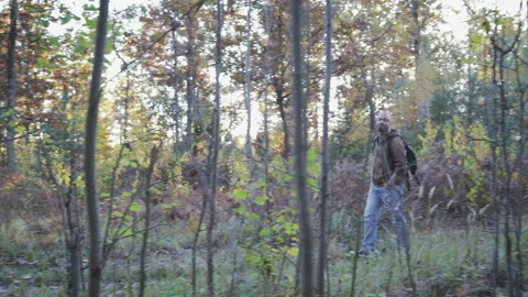 A young guy, a man walks through the woods and enjoys the autumn landscape Stock Footage 97316970