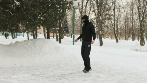 Young guy in a mask on his face, in a black sports suit, performing exercises Stock Footage 108831387