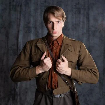 A young guy in military-style clothes, a brown flight jacket and breeches Stock Photos