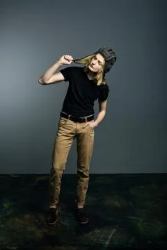 A young guy model posing in a tankman helmet on the gray background. Stock Photos