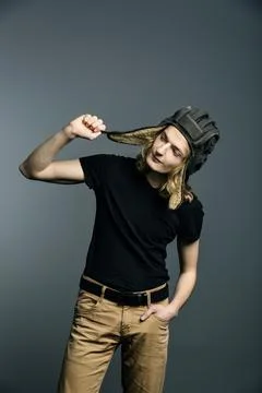 Young guy model posing in a tankman helmet on the gray background Stock Photos