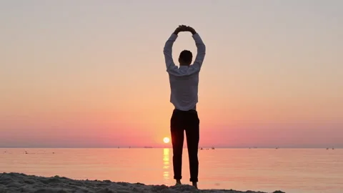 A young guy in office clothes is warming up on the seashore Video stock 145887911