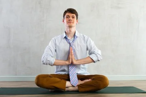 Young guy office worker doing yoga in studio Stock-Fotos