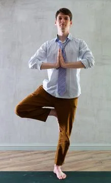Young guy office worker doing yoga in studio Foto stock