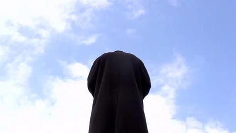 A young guy opens his long coat against the sky Stock Footage 274695341