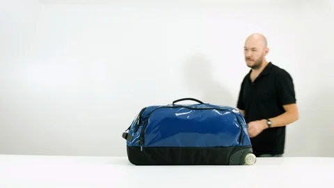 Young guy opens a travel bag. Man with travel bag Stock Footage 102553726