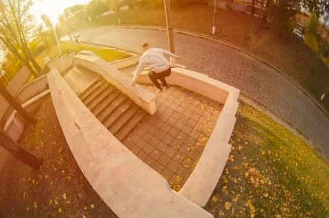 A young guy performs a jump through the space between the concrete parapets.  写真素材