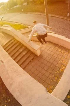 A young guy performs a jump through the space between the concrete parapets.  写真素材