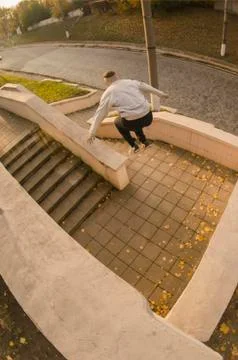 A young guy performs a jump through the space between the concrete parapets.  写真素材