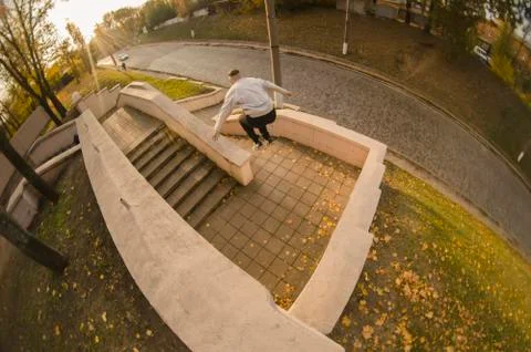 A young guy performs a jump through the space between the concrete parapets.  写真素材
