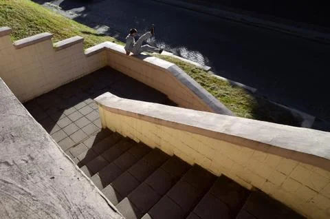 A young guy performs a jump through the concrete parapet. The athlete practic Stock Photos