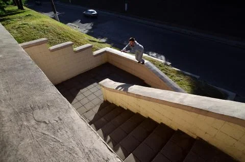 A young guy performs a jump through the space between the concrete parapets.  写真素材