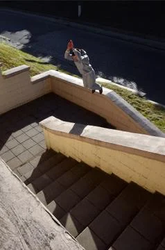 A young guy performs a jump through the space between the concrete parapets.  写真素材