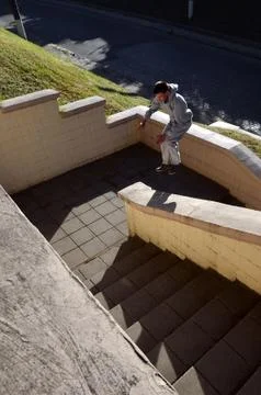 A young guy performs a jump through the space between the concrete parapets.  写真素材