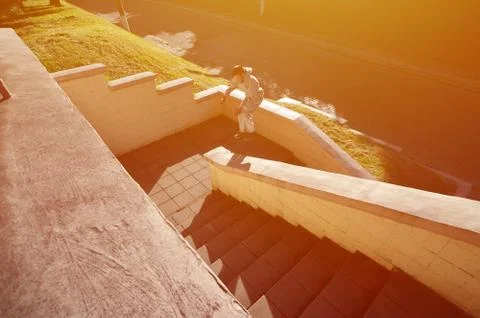 A young guy performs a jump through the space between the concrete parapets.  写真素材