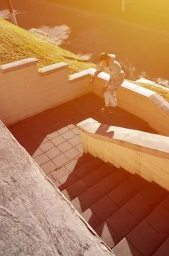 A young guy performs a jump through the space between the concrete parapets.  写真素材