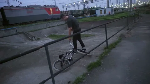 Young guy picks up a bicycle from the ground and rides on it 스톡 동영상 103043396