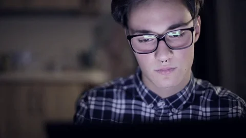 A young guy with piercings playing tablet Stock Footage