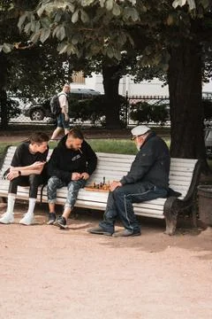 A young guy is playing chess with an old man in the park Foto stock