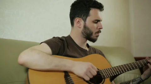 A young guy playing the guitar Stock Footage 61886265