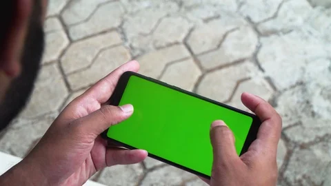 Young guy playing on his phone green screen games enjoying smartphone Stock Footage 127808360