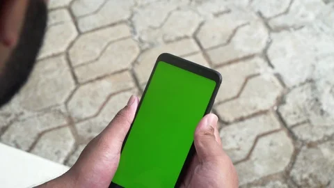Young guy playing on his phone green screen games enjoying smartphone Stock Footage 127808906