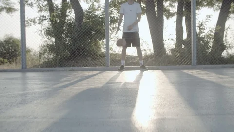 A young guy plays with a ball at dawn. Stock Footage 121093080