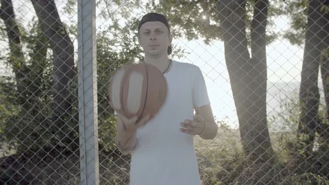 A young guy plays with a ball at dawn. Stock Footage 121093341