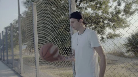 A young guy plays with a ball at dawn. Stock Footage 121093386