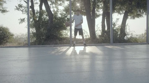 A young guy plays with a ball at dawn. Stock Footage 121093735