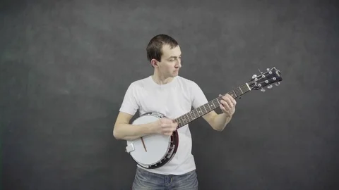 Young guy plays the banjo. Black background Stock Footage 71680281
