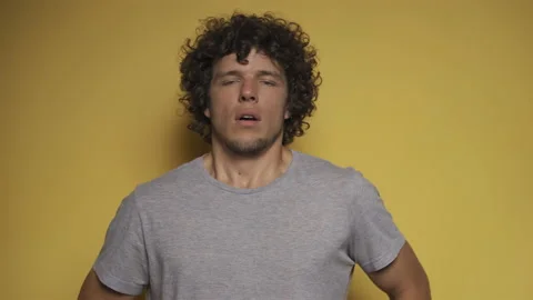 Young guy portrays a fright in the studio against an isolated background. He Stock Footage 142213278