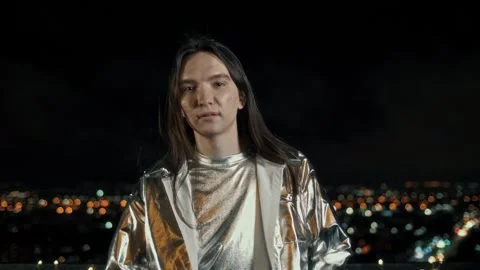 Young guy poses and children on camera on the roof of a skyscraper at night Stock Footage 312077663