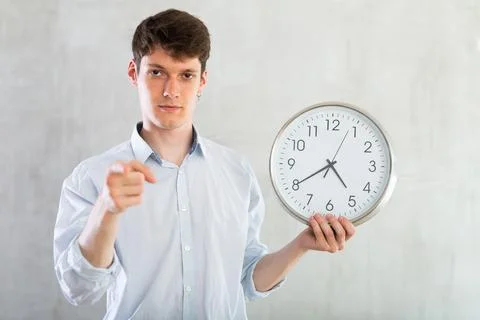 Young guy posing with clock in studio Stock Photos