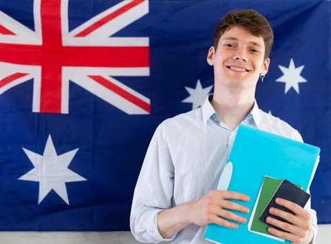 Young guy posing with documents against background of Australian flag Foto stock