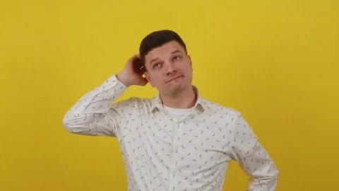 Young guy posing on a yellow background. Thinks, fantasizes, dreams and seeks Stock Footage 172055544