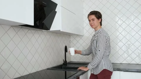 Young guy pours water into mug and drinks. Clean tap water. Ecology Water filter 스톡 동영상 140920733