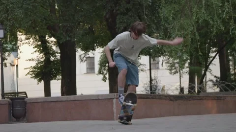 A young guy practices skateboard tricks alone in the park. Stock Footage 252215806