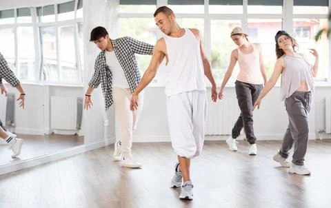 Young guy practicing basic hip hop steps in training hall 스톡 사진