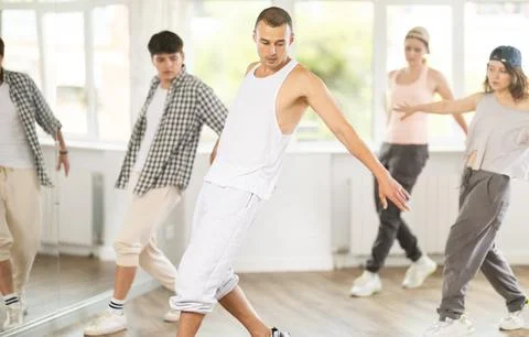 Young guy practicing basic hip hop steps in training hall 스톡 사진