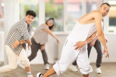Young guy practicing basic hip hop steps in training hall 写真素材