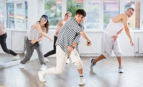 Young guy practicing basic hip hop steps in training hall 写真素材